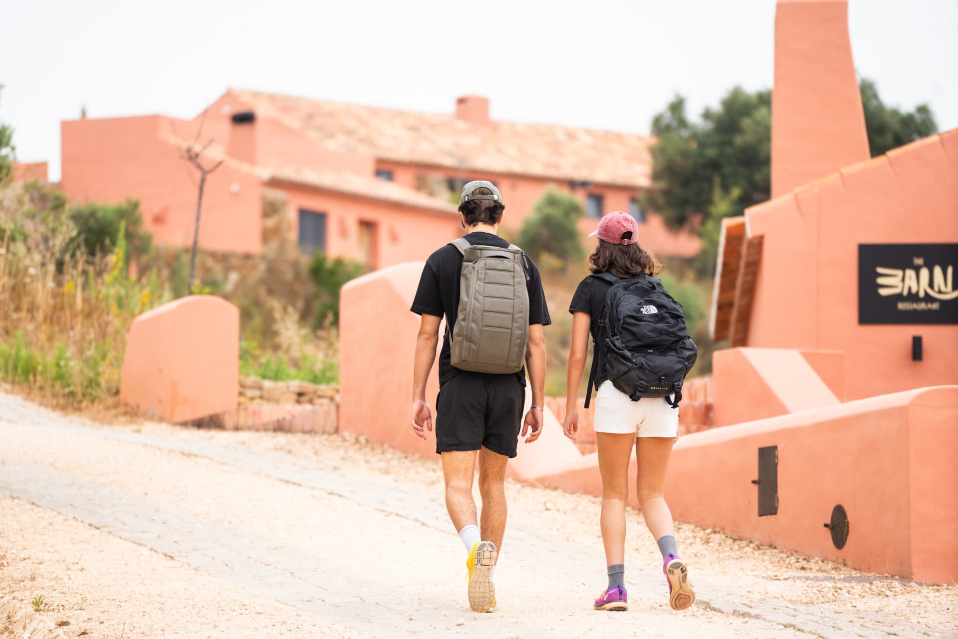 Two walkers arriving at a terracotta rural hotel in Portugal
