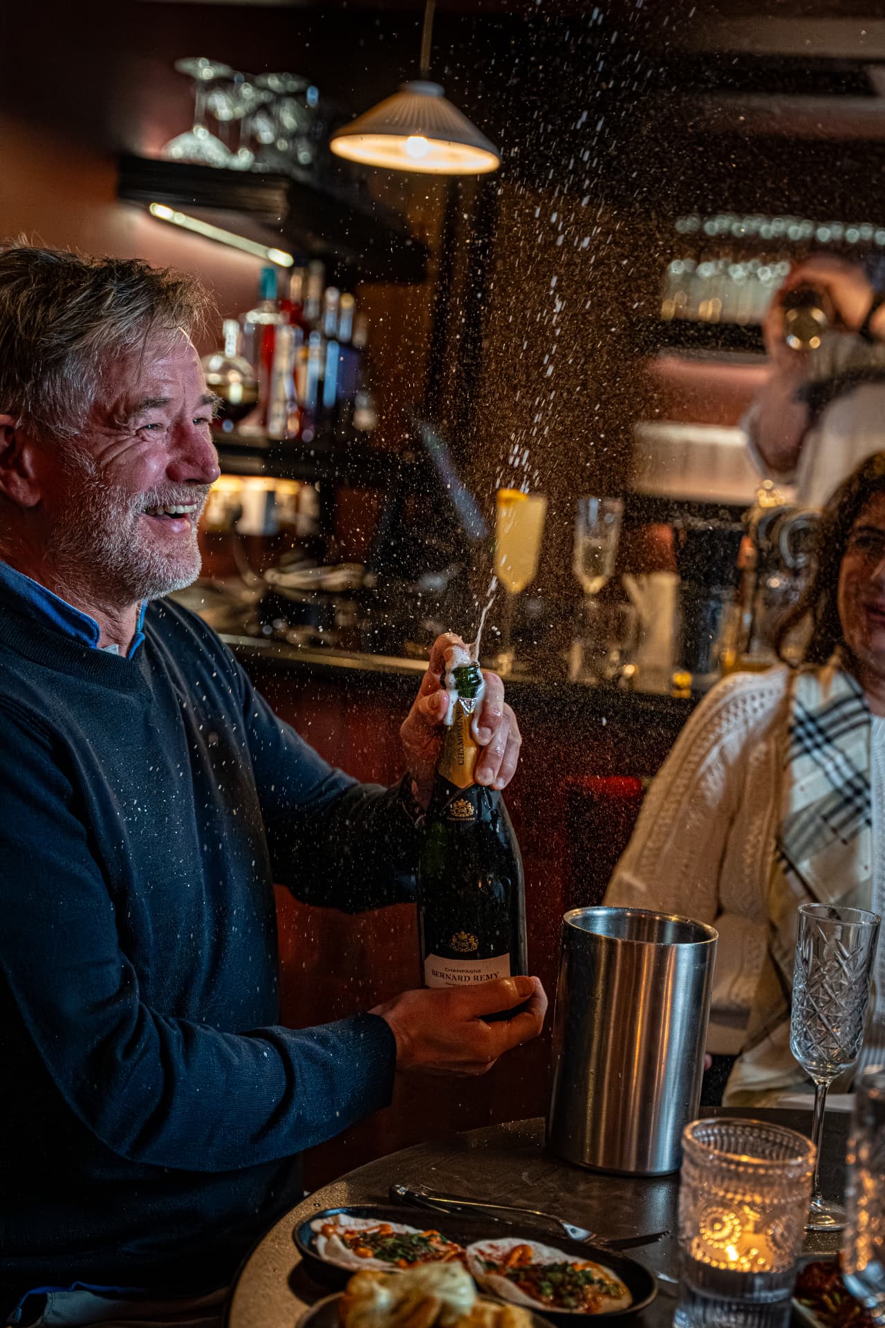 A guest celebrating with a spray of champagne at a hotel party